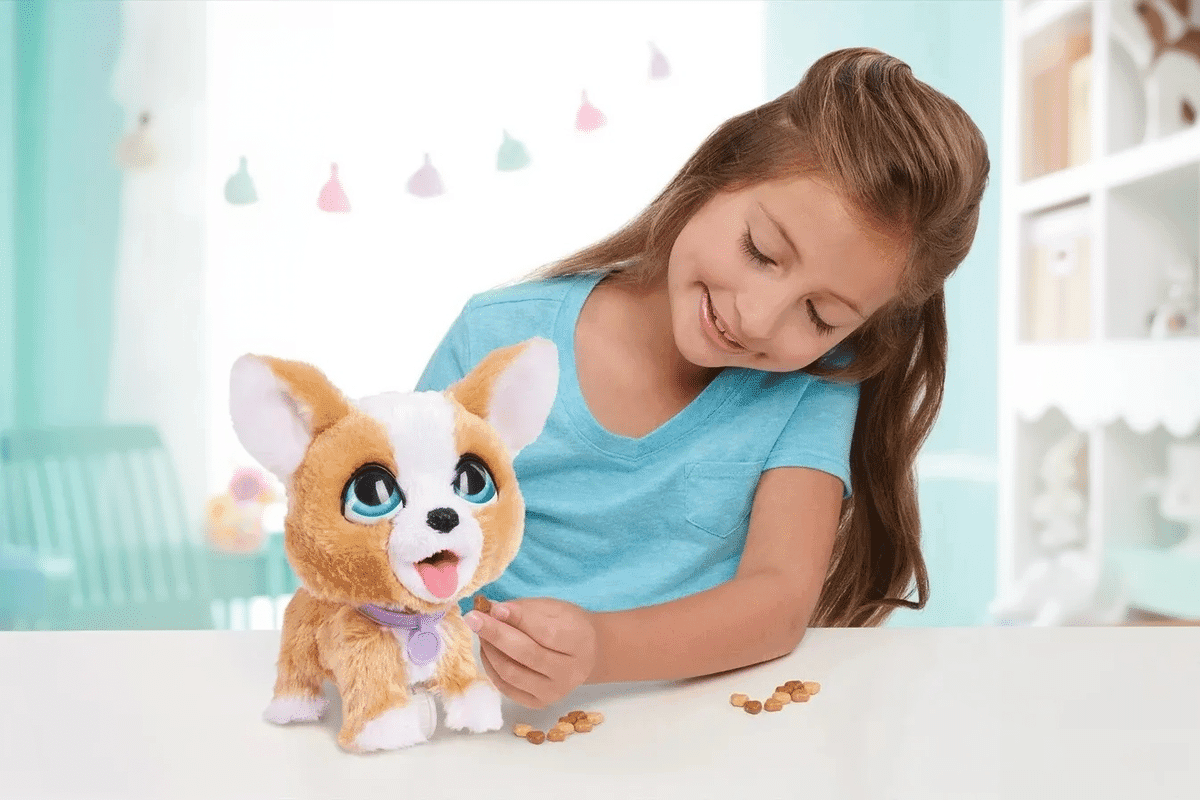 Interaktive hunde. En pige sidder ved hendes skrivebord og fodre hendes legetøjs robot hund.