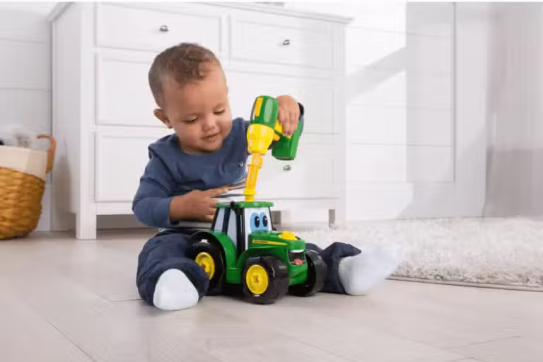 byggesæt til børn . En lille dreng sidder og leger med et John Deere Byg Selv